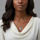 Woman wearing a silver necklace with a cross pendant against a gray background