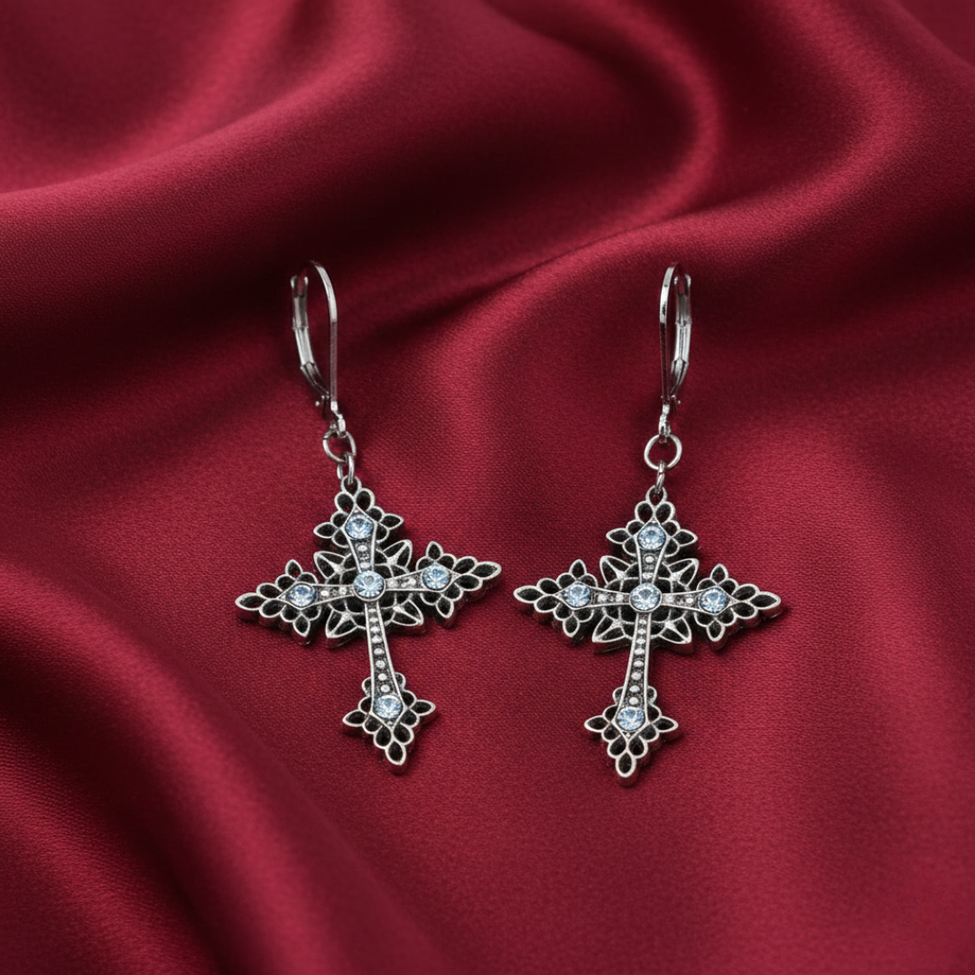 Symbols Of Faith Croce Elegante Light Sapphire Crystal Drop Earrings on a red fabric