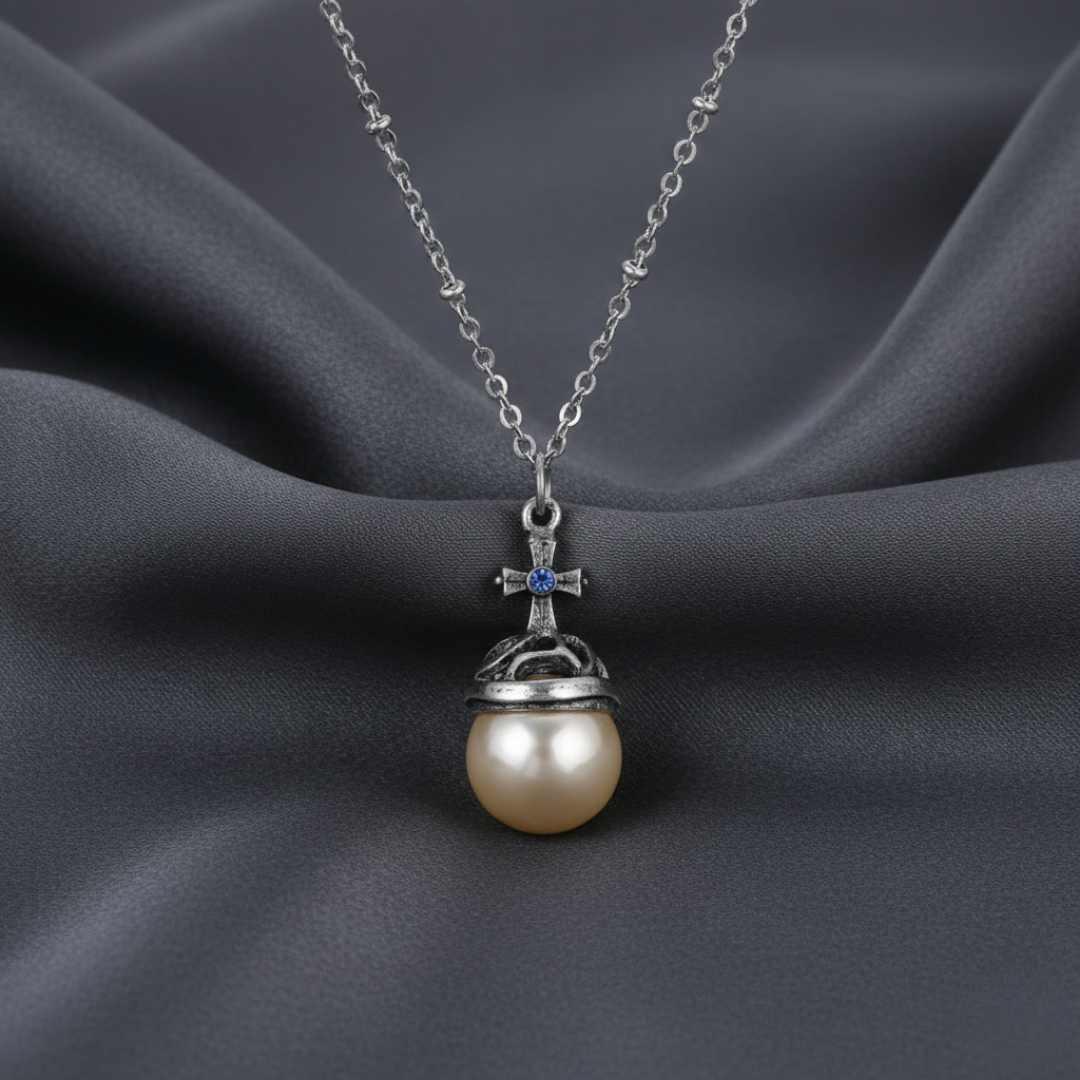 Cross pearl necklace with silver chain on a dark fabric background