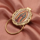 Decorative eyeglass holder with religious icon on a pink fabric background