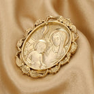 Gold religious brooch on a beige fabric background