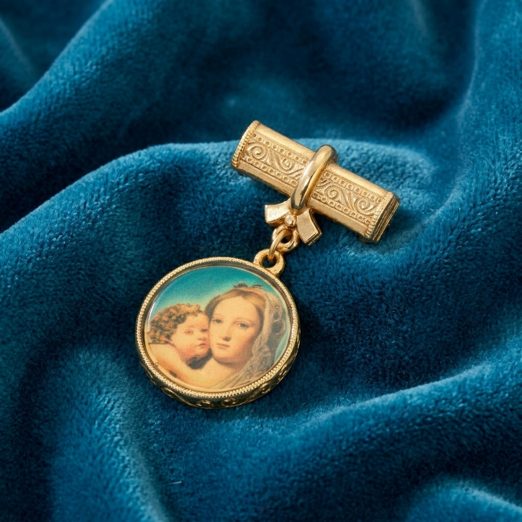 Gold tone Mother Mary and Child brooch resting on blue fabric