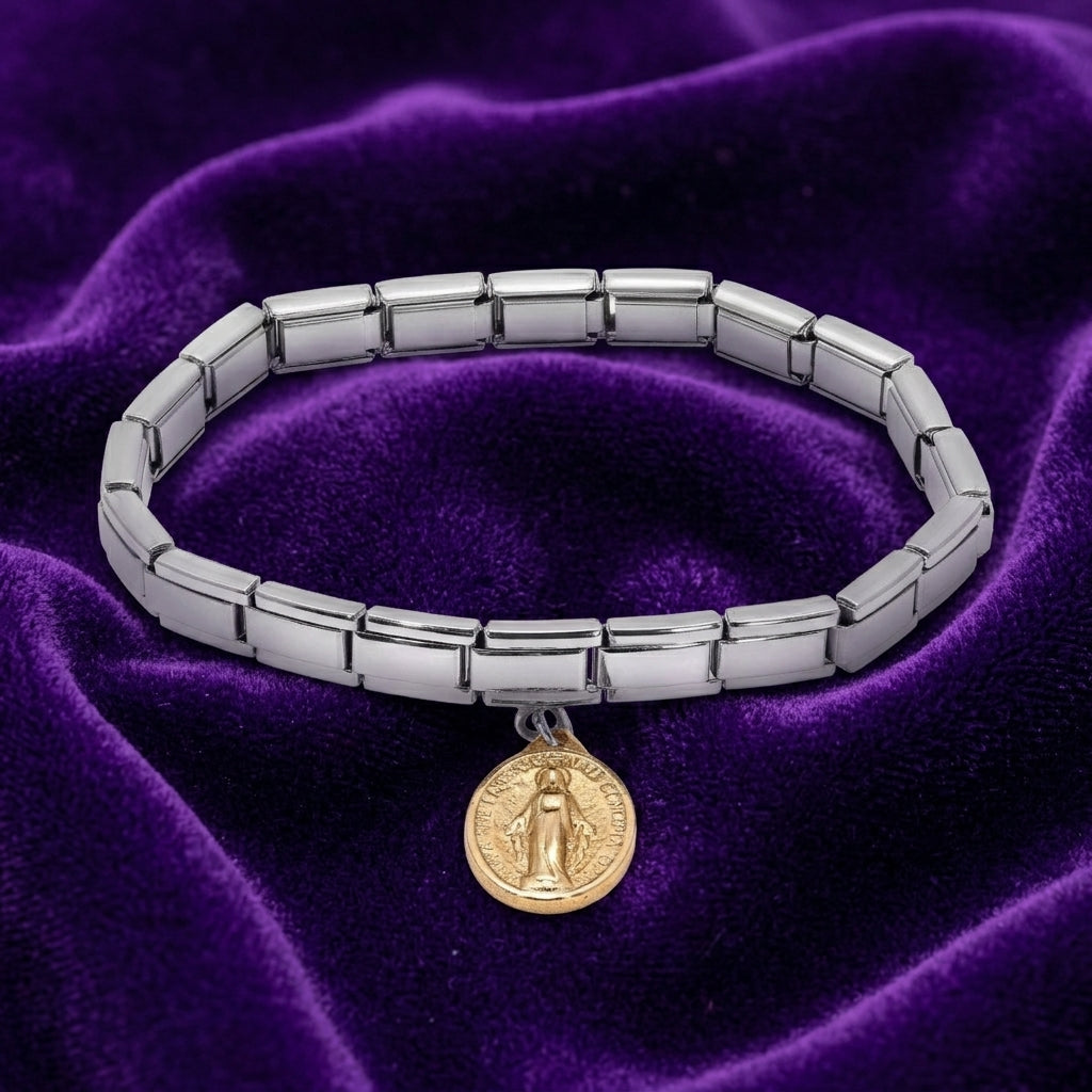 Silver bracelet with a gold Mother Mary charm on a purple velvet background