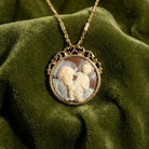 Vintage-style necklace with a round brown and ivory cameo St. Christopher and Jesus pendant on a green fabric background