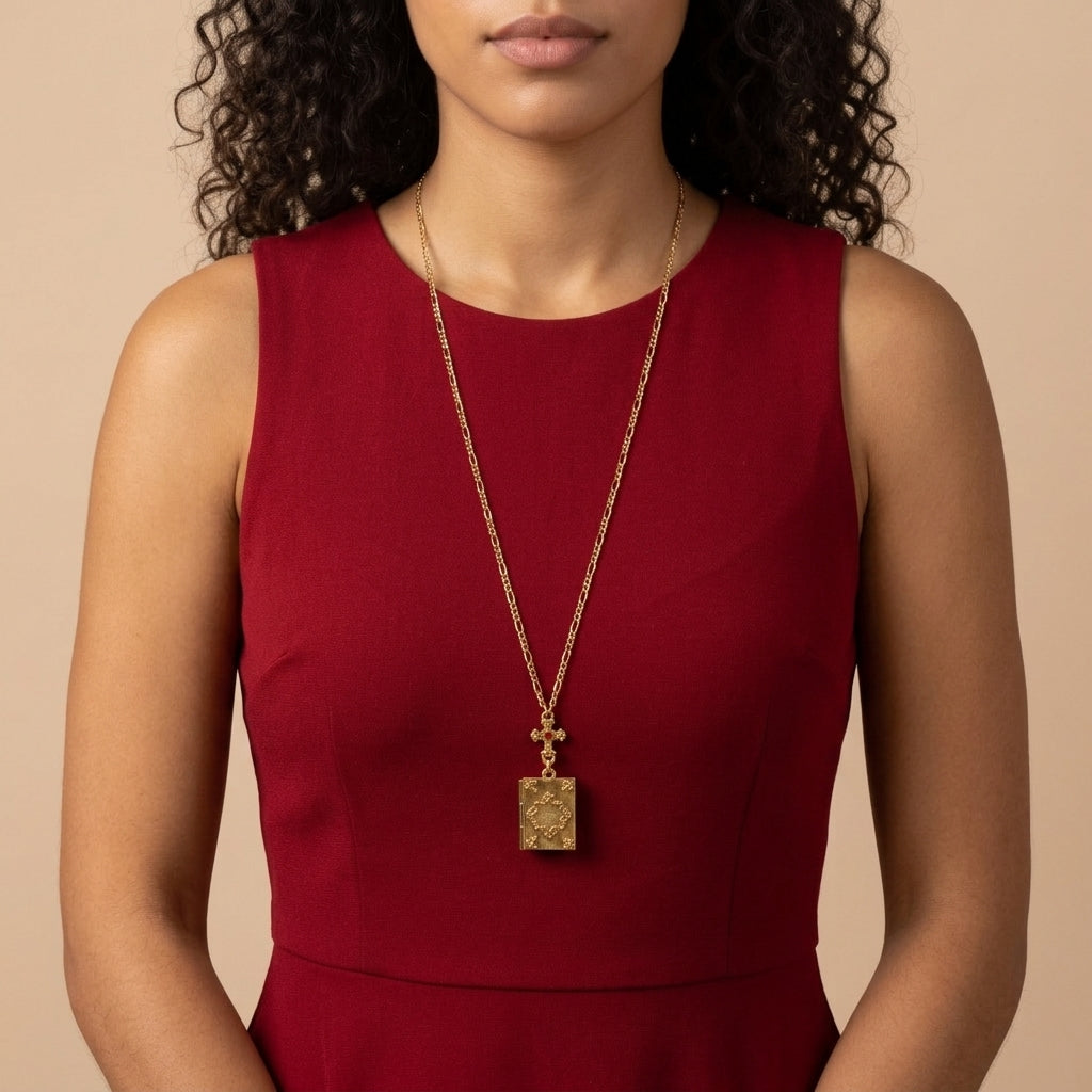 Woman wearing a red dress and gold Holy Bible locket necklace against a beige background