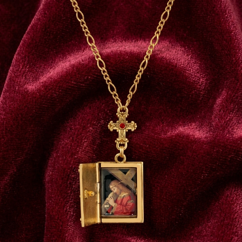 Gold necklace with an open Bible locket featuring a religious scene on a red velvet background