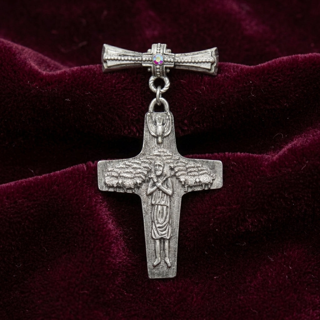 Silver cross brooch pin with a figure on a red velvet background