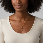 Woman wearing a gold necklace with a red "A" initialed pendant against a neutral background.