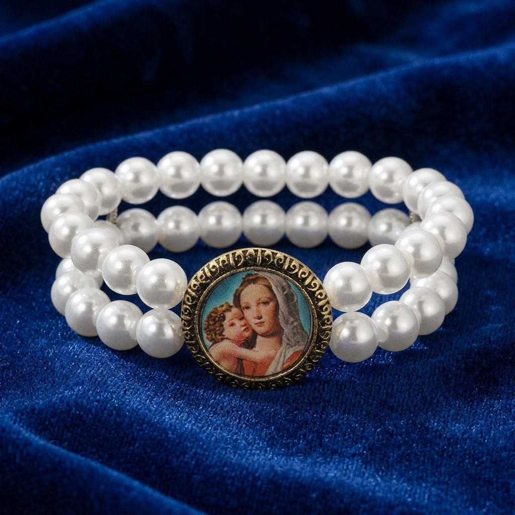 Pearl bracelet with a religious Mary and Child emblem on a blue fabric background