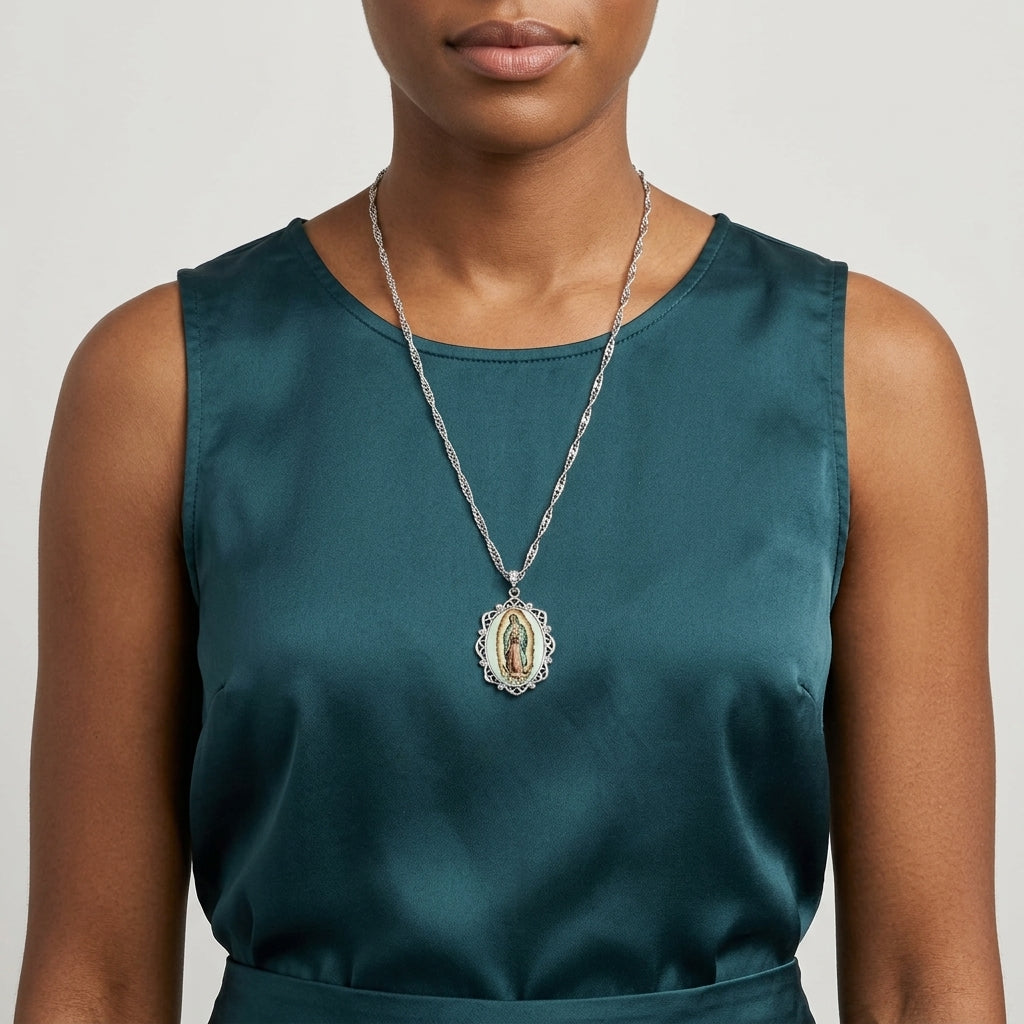Woman wearing a green sleeveless top with a necklace featuring a religious pendant.