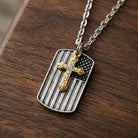 Necklace with a pendant featuring a gold tone cross on an American flag dog tag, displayed on a wooden surface.