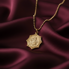 Close-up of St. Christopher gold pendant necklace with a Child and engraved faith inscription on a ball chain.