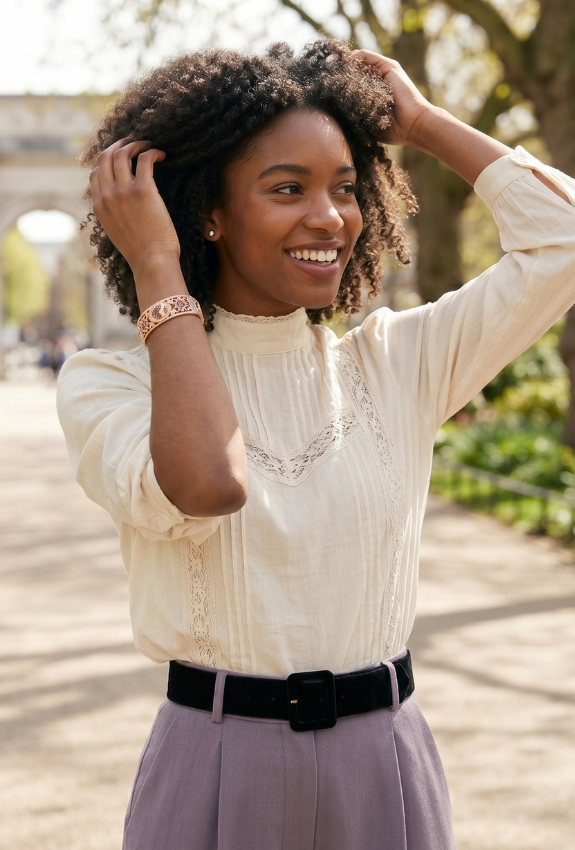 Woman adjusting her hair outdoors showcasing a victorian-style floral bracelet on her wrist. 